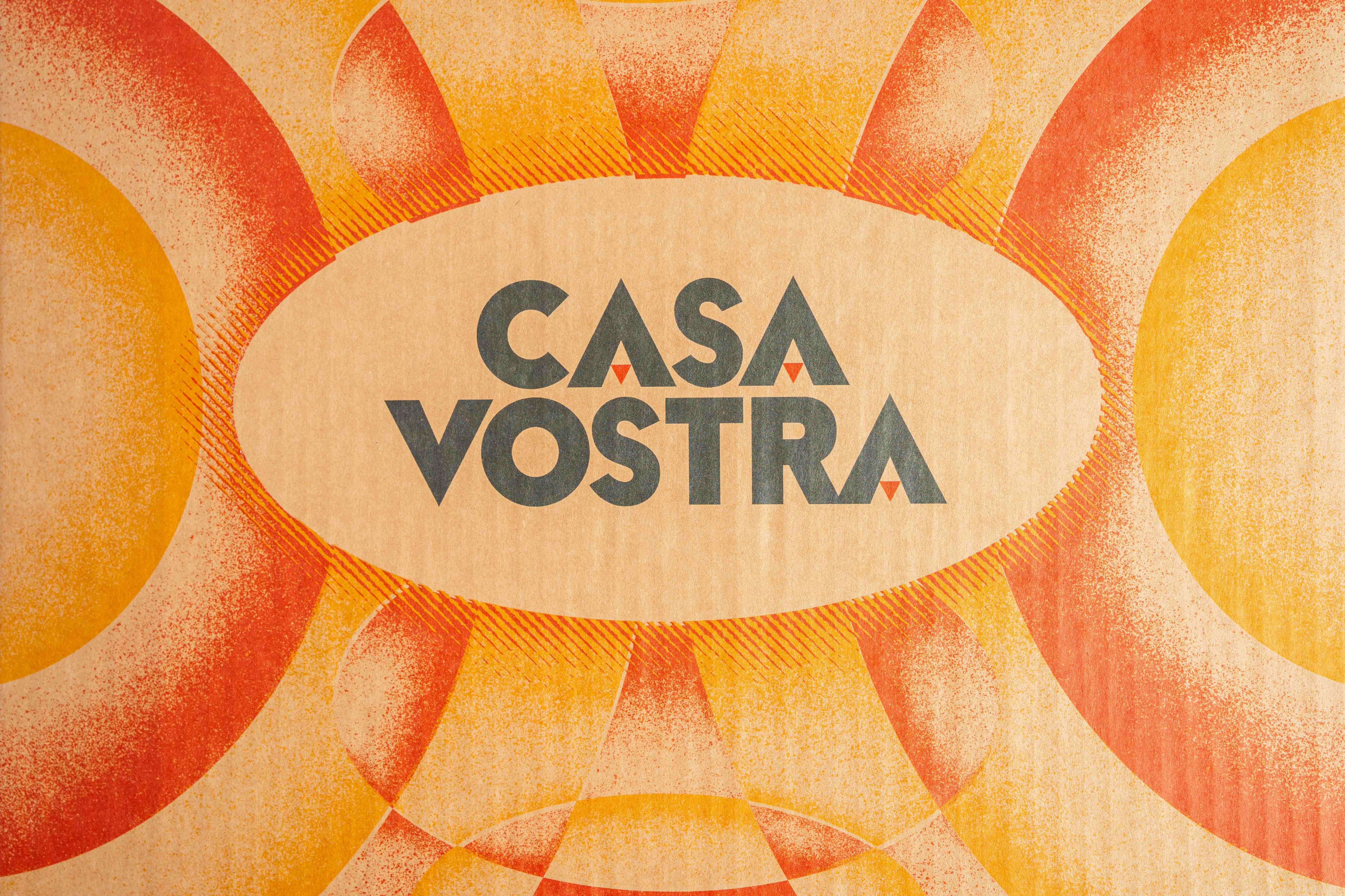 Close-up of the kraft sunburst print with the CASA VOSTRA wordmark inside an oval
