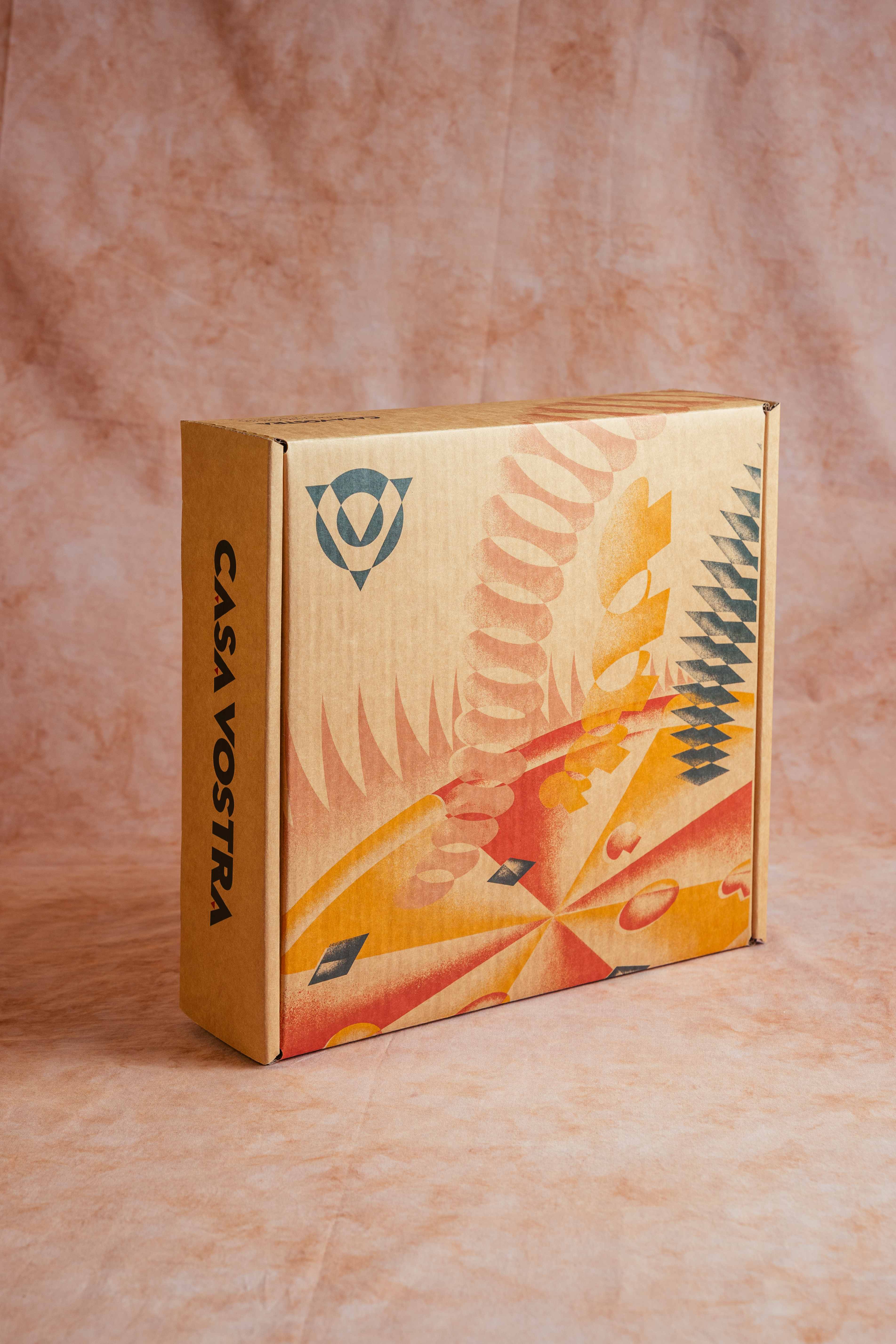 Casa Vostra box standing upright with a Futurist pasta-and-geometry illustration on a terracotta backdrop