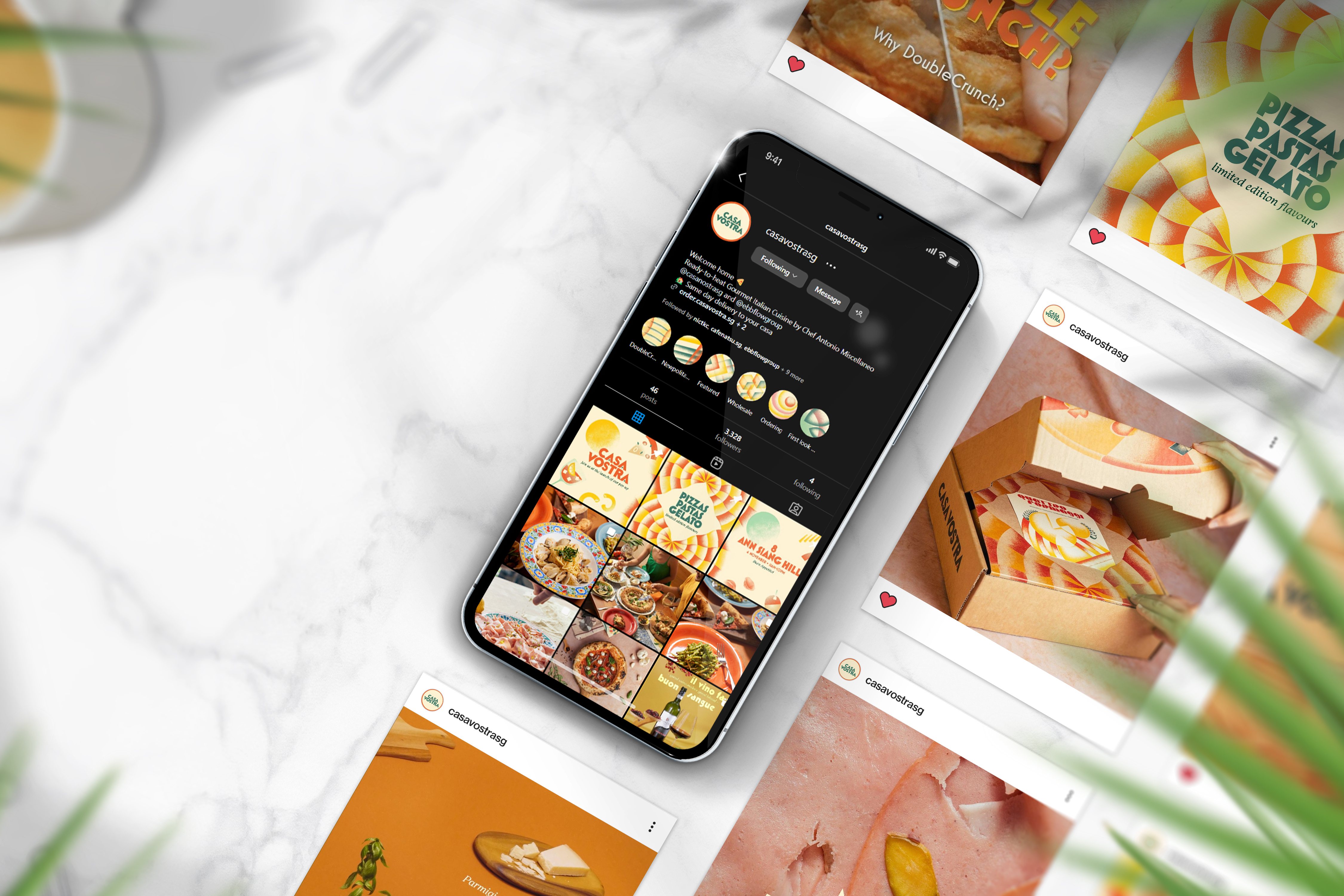 iPhone showing the Casa Vostra Instagram profile, surrounded by social post mockups on marble