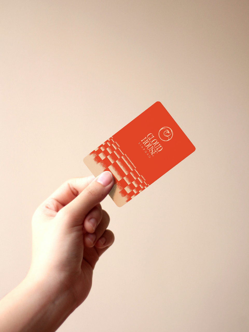 Coral key card with gold foil logo and pixel pattern, held in hand