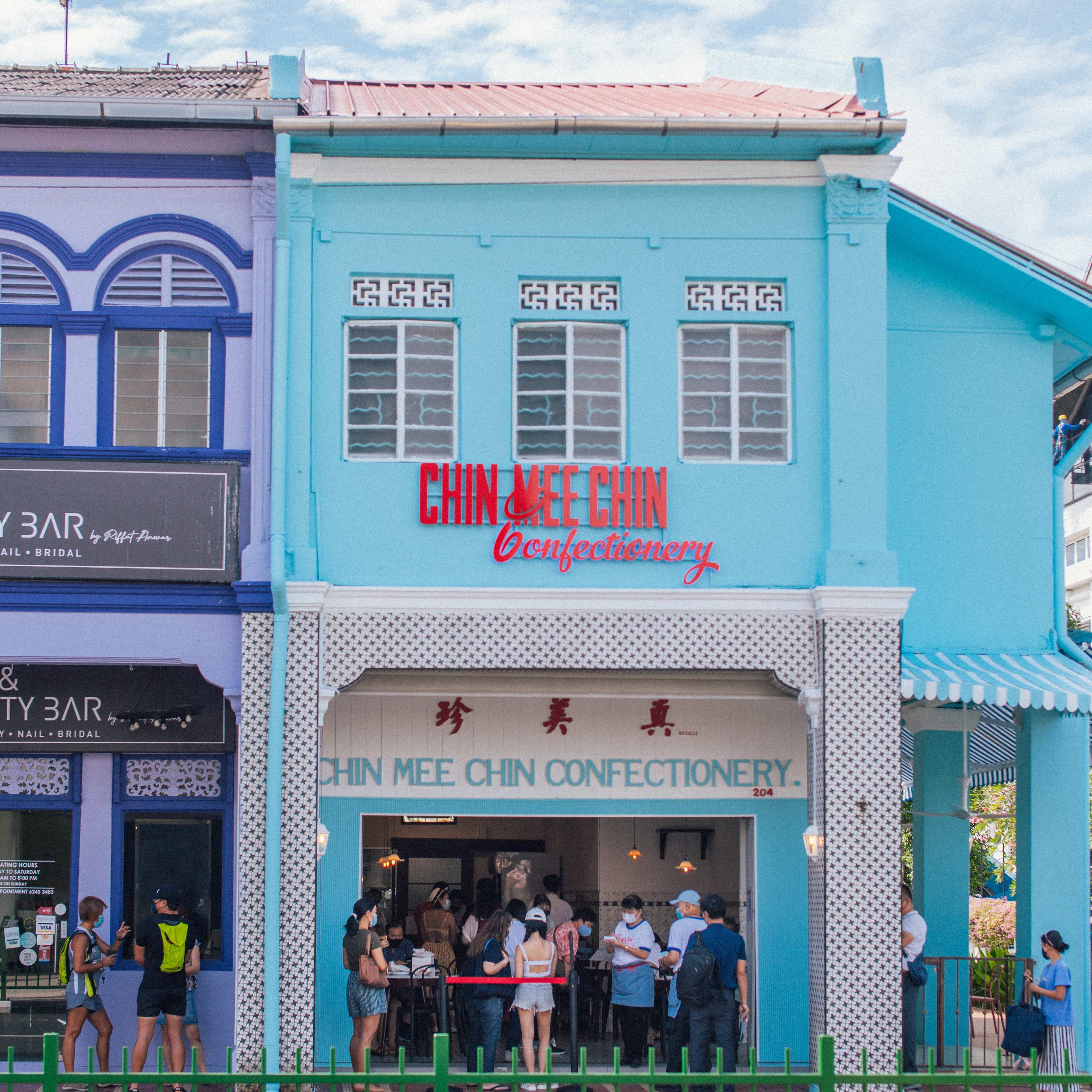 Full shophouse exterior — the sky-blue building with red Chin Mee Chin Confectionery signage viewed from across the street