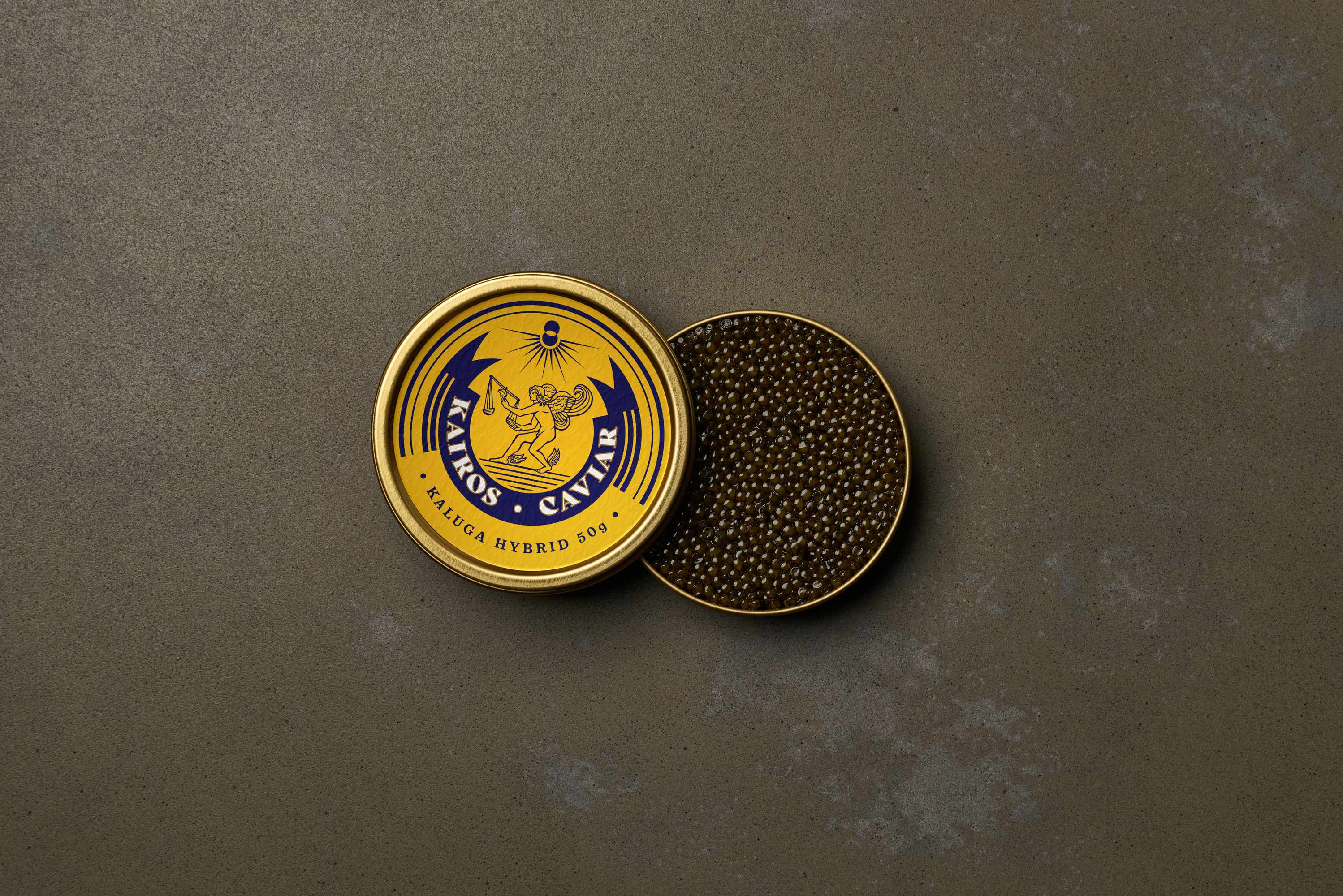 An open yellow Kaluga Hybrid Kairos Caviar tin beside its lid full of caviar on a grey concrete surface