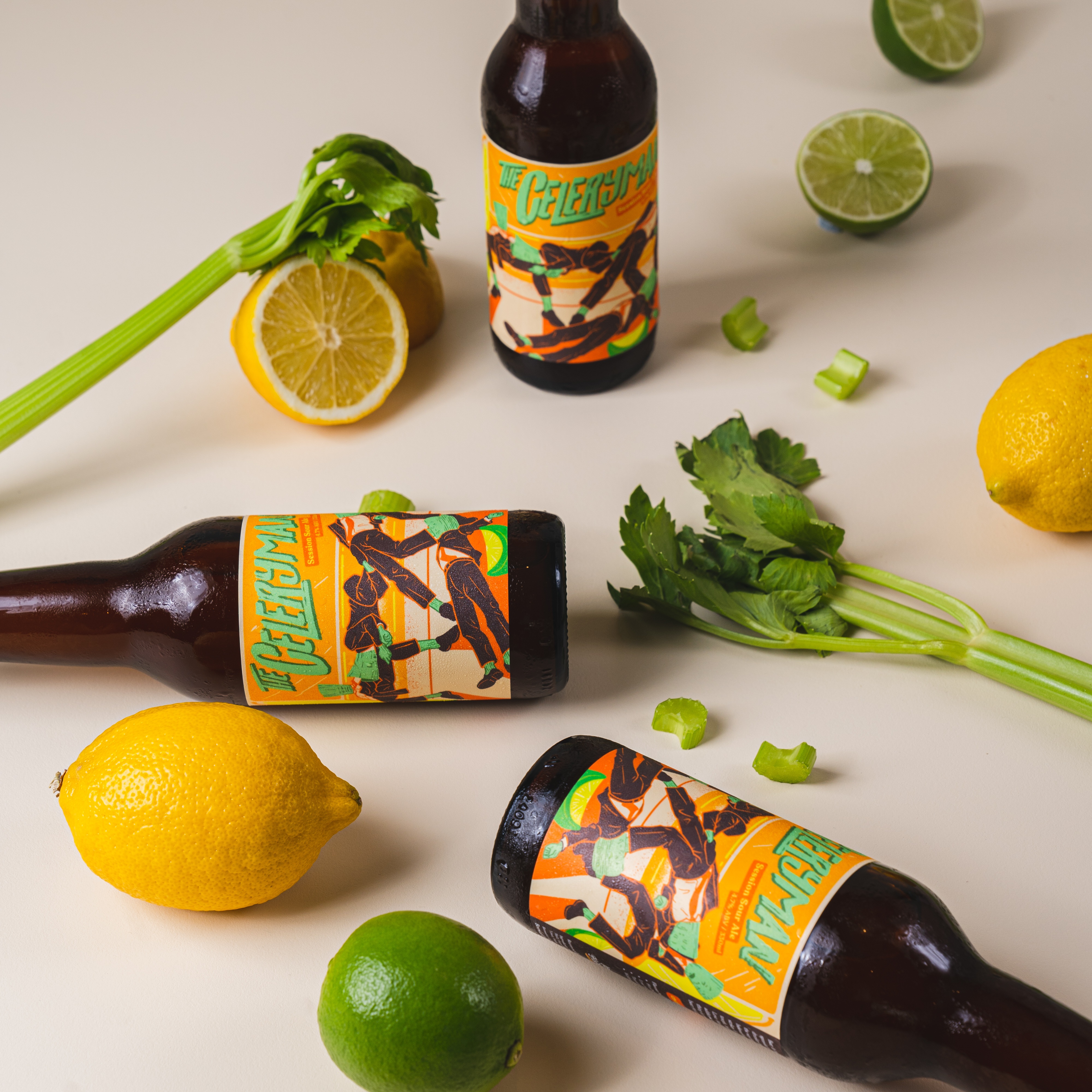 Three bottles of The Celeryman session sour ale on a cream backdrop styled with lemons, limes and celery, showing the orange retro label with green illustrated figures